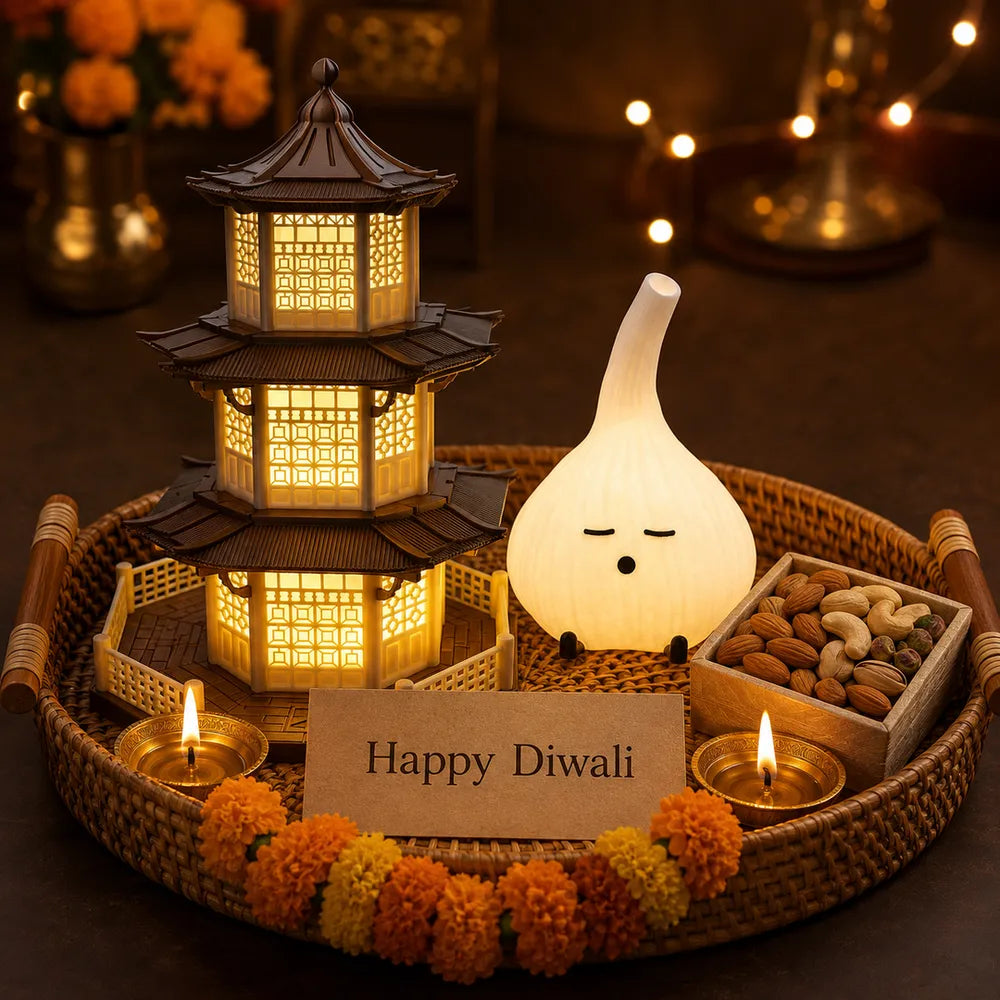 Diwali corporate hamper with a 3D-printed pagoda lamp, garlic night light, diyas and marigold